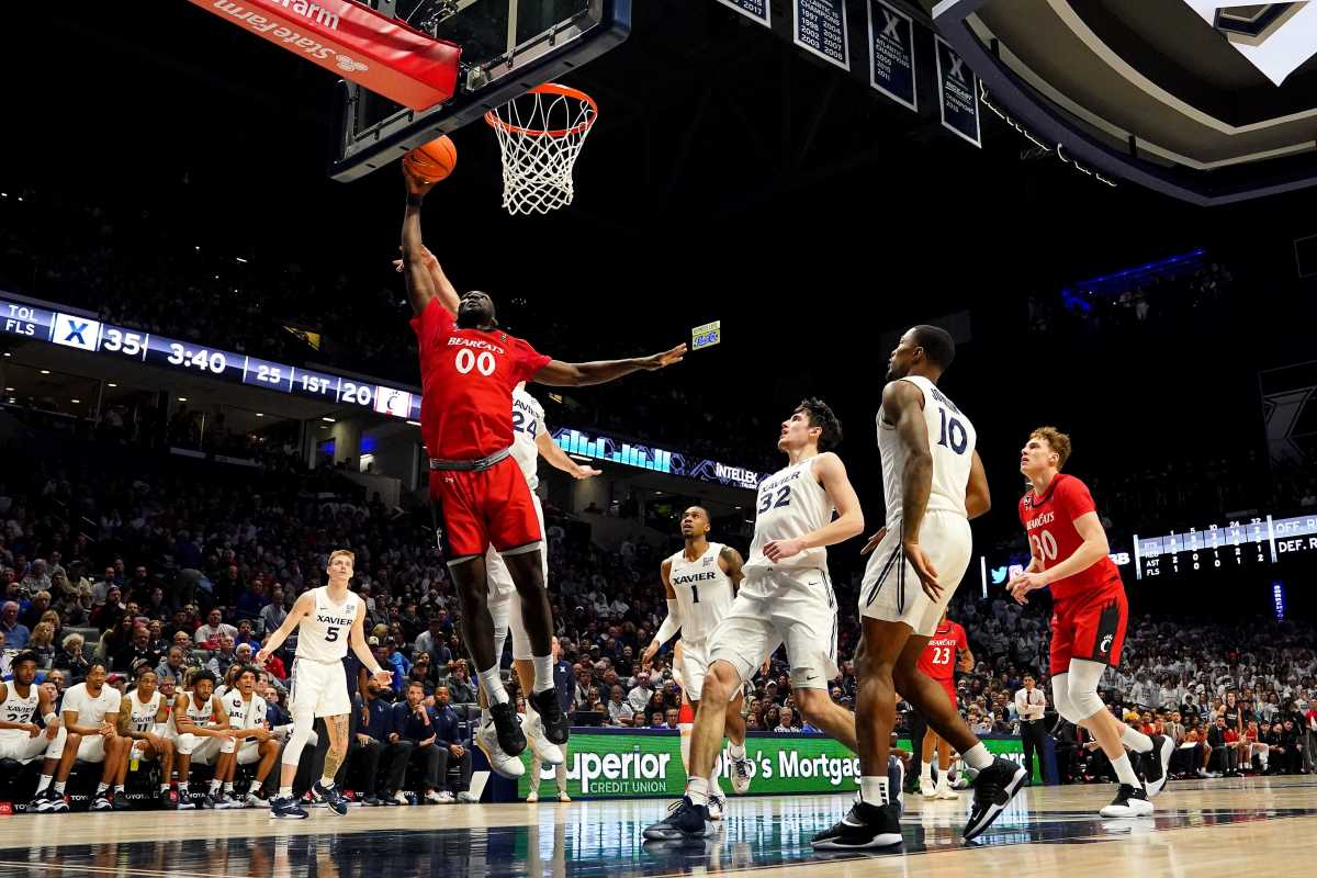 Cincinnati Bearcats forward Abdul Ado (00) rises to the basket as Xavier Musketeers forward Jack Nunge (24) defends in the first half of the 89th Annual Crosstown Shootout college basketball game, Saturday, Dec. 11, 2021, at Cintas Center in Cincinnati. The Xavier Musketeers won, 83-63. Xavier Musketeers At Cincinnati Bearcats 89th Crosstown Shootout Dec 11